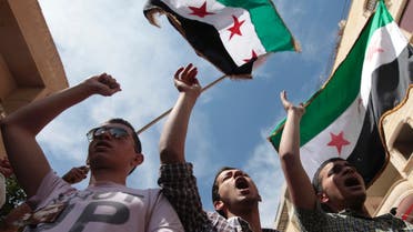 Demonstrators chant slogans and wave Syrian opposition flags during a protest against President Bashar al-Assad after Friday prayers in Raqqa province, east Syria, May 17, 2013. REUTERS