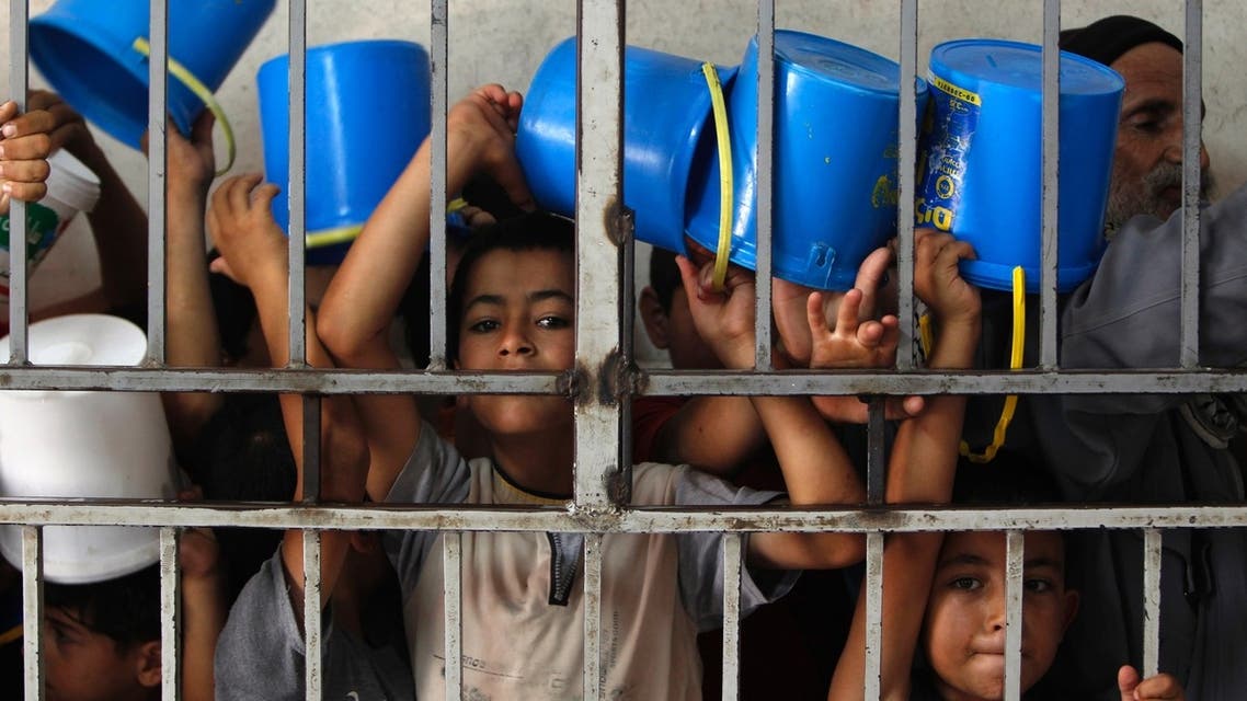 Palestinian children wait to receive food at a soup kitchen in the West Bank city of Hebron in August 2010. (File photo: Reuters)