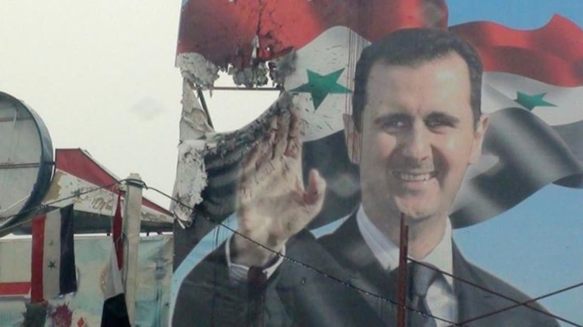 A poster depicting Syria's President Bashar Assad is seen damaged in Duma, near Damascus, 25 January 2012. (Photo: Reuters