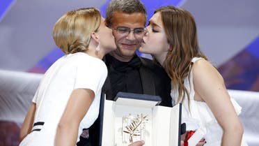 French actresses Lea Seydoux (L) and Adele Exarchopoulos kiss French-Tunisian director Abdellatif Kechiche after he was awarded on May 26, 2013 with the Palme d'Or for the film "Blue is the Warmest Colour" during the closing ceremony of the 66th Cannes film festival in Cannes.