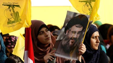 Lebanese women wave Hezbollah flags while holding a picture of the movement’s chief Hassan Nasrallah in Mashghara in the western Bekaa Valley on May 25, 2013. (AFP)