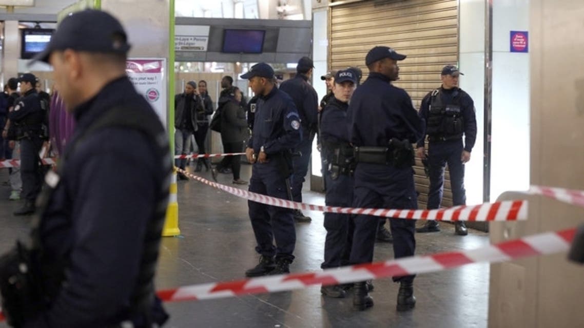 Police officers stand at the site where a man attacked a French soldier patrolling a Metro-station mall on the western edge of Paris. (AFP)
