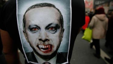 Turkish Prime Minister Recep Tayyip Erdogan is depicted as a vampire in a picture pinned on the back of a protestor during a demonstration of several thousand Alevites in the western German city of Bochum 17 March 2012.