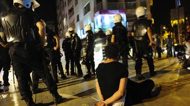 A demonstrator sits on the ground after he was detained by riot police during an anti-government protest in Izmir, western Turkey, June 2, 2013. (Reuters)