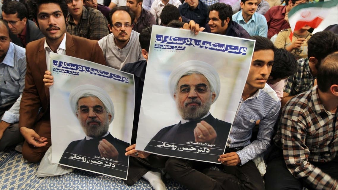 Iranian supporters hold a poster featuring Hassan Rowhani, a moderate Iranian presidential candidate, during an election campaign at the Jamaran mosque in Tehran, on June 1, 2013. (File Photo: AFP)