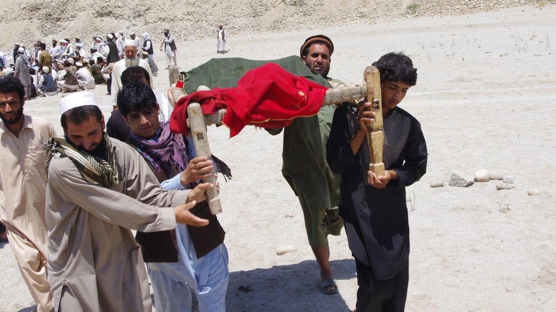 Afghan men carry the body of a victim of a suicide attack at Mehtarlam city, capital of Laghman province on June 3, 2013.