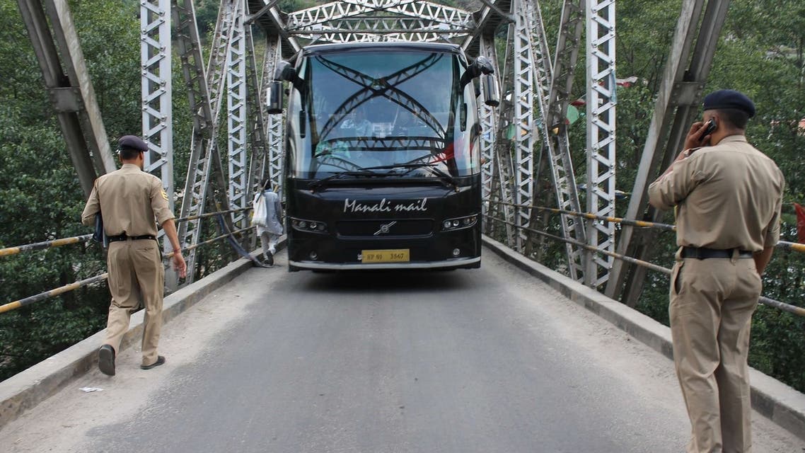 Indian police stop a tourist bus at a checkpoint put in place following the rape of a US tourist in the Indian hillstation town of Manali on June 5, 2013. AFP