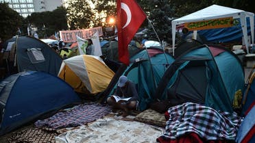 A demonstrator reads a magazine, amongst tents in Gazi park next to Taksim square in Istanbul early on June 8, 2013.