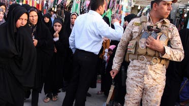 Iranian Shiite Muslim pilgrims walk past a member of Iraq's security personnel in Kerbala, 110 km south of Baghdad, June 7, 2013. (Reuters)