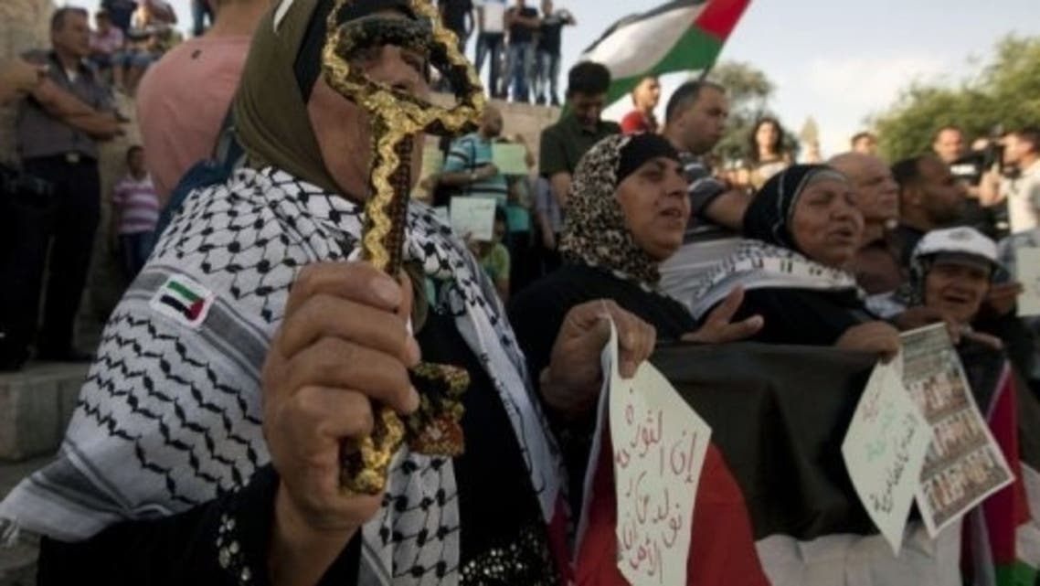A Palestinian woman holds a symbolic key during a rally to mark the 46th anniversary of Israel's occupation of the West Bank and Gaza Strip, on June 5, 2013 at Damascus Gate in Jerusalem. (AFP)