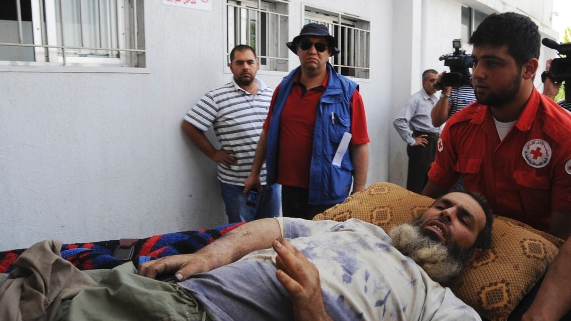 Lebanese Red Cross personnel transport a Syrian refugee injured in the fighting between Syrian government troops and rebel fighters in the Syrian border town of Qusair, to a hospital in Jib-Janine town, Bekaa Valley June 8, 2013. (Reuters)