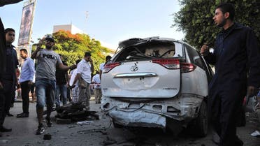 Members of security and civilians gather near an Italian diplomatic car after experts detonated a bomb that was discovered planted underneath it, in Tripoli June 11, 2013. REUTERS