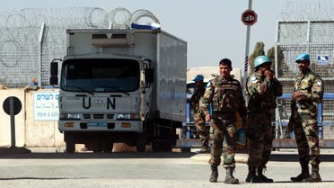 U.N. peacekeeping soldiers stand near vehicles at the Quneitra border crossing between Israel and Syria, in the Israeli-occupied Golan Heights June 11, 2013. (Reuters)
