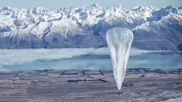 A Google balloon sails through the air in Tekapo, New Zealand with the Southern Alps mountains in the background.