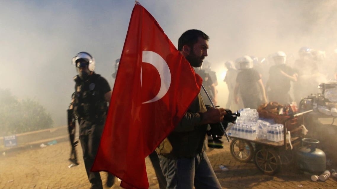 A protester holds a Turkish flag as riot police order them to evacuate Gezi Park in central Istanbul June 15, 2013. (Reuters)