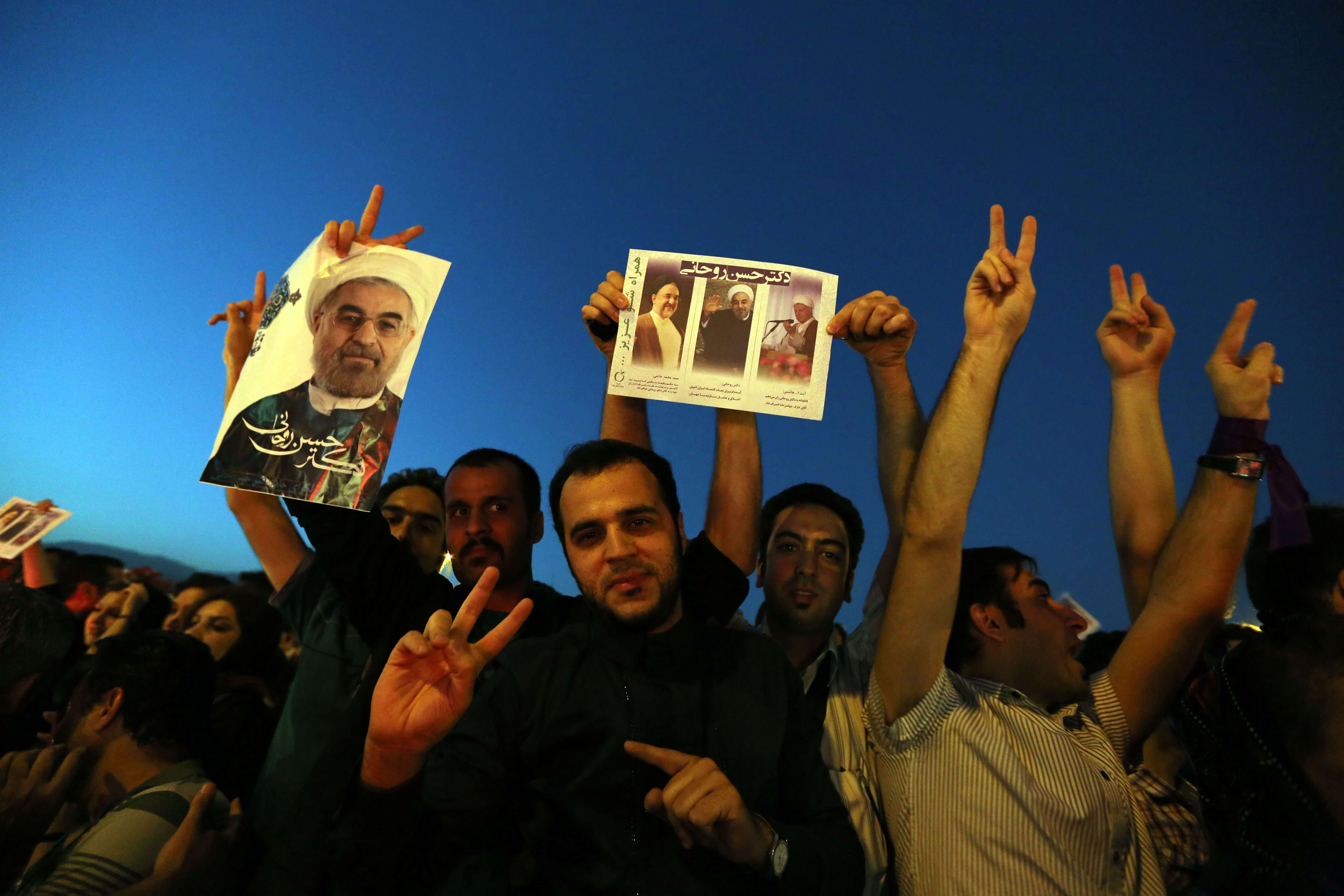 Iranians celebrate the victory of moderate presidential candidate Hassan Rowhani (portrait) in the presidential elections at Vanak Square, in northern Tehran, on June 15, 2013. (AFP)