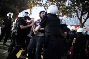 A protester is detained by Turkish riot police officers as they chase out demonstrators and dismantle the tent camp set up by demonstrators in Gezi Park in Istanbul June 15, 2013. (AFP)