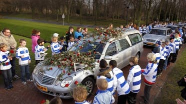 Members of Dutch football club SC Buitenboys wearing the colors of the club stand to they pay respect to Dutch linesman Richard Nieuwenhuizen as the hearse carrying the body of Nieuwenhuizen arrives at the crematory. (File Photo: AFP)
