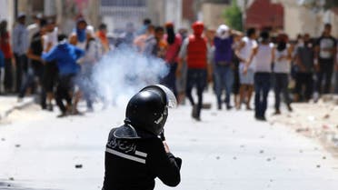 A riot police officer fires teargas during clashes with supporters of Islamist group Ansar al-Sharia in Tunis on May 19. (Reuters)