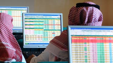 Saudi traders monitor stocks at a Saudi Bank in Dammam. A change in the weekend timing is expected to give a boost to business, economists say. (File photo: Reuters)