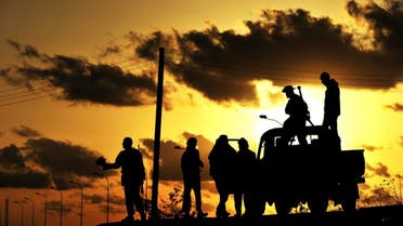 Libyan rebel fighters are silhouetted at sunset on March 7, 2011 in the oil center of Brega. AFP