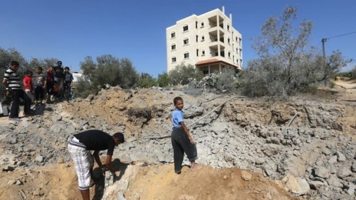 Palestinian youth inspect the damage following an Israeli air raid on al-Zawaida in the central Gaza strip early on June 24, 2013. The International Monetary Fund said Wednesday that Israel's tight restrictions hinder the growth of the Palestinian private sector, holding back the Palestinian economy. (AFP)