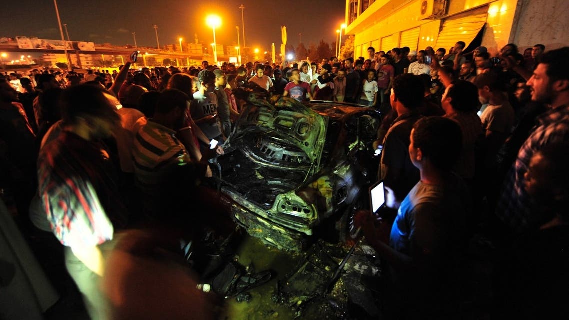 Onlookers gather around the wreckage of a car, which exploded near members of a special forces unit, in Benghazi, July 3, 2013.