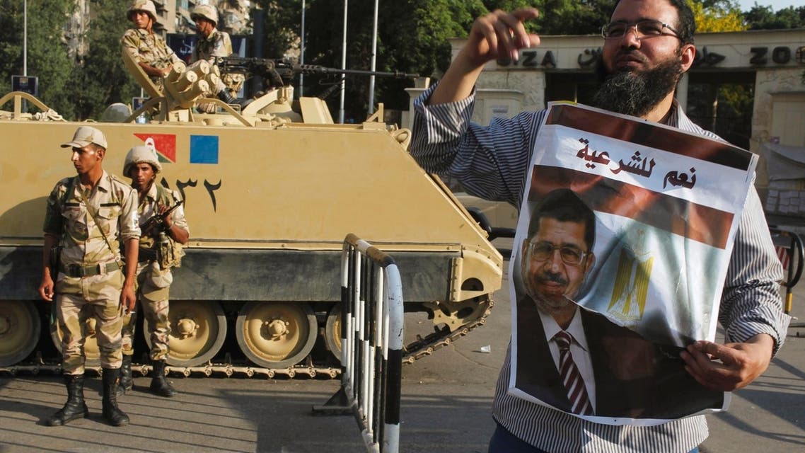 Army soldiers stand guard near a supporter of ousted President Mohamed Mursi at Cairo University in Giza, on the outskirts of Cairo July 4, 2013. Reuters