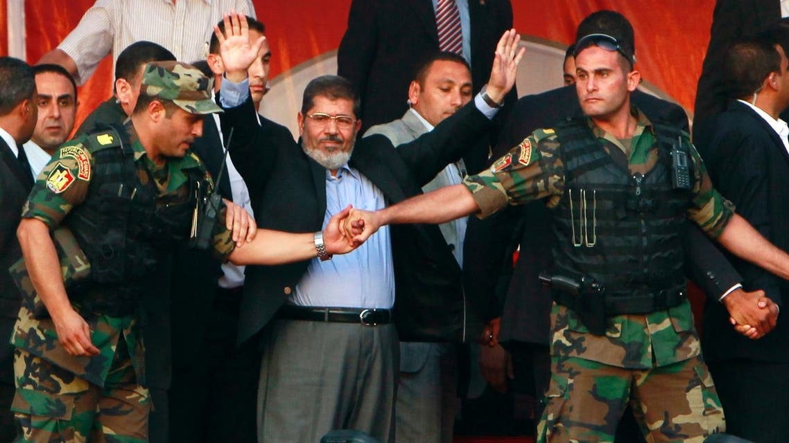 Only a year ago: Egypt's then President-elect Mohammed Mursi waves to his supporters while surrounded by members of the presidential guard in Cairo's Tahrir Square on June 2012. (Reuters)