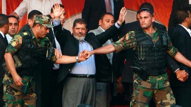 Only a year ago: Egypt's then President-elect Mohammed Mursi waves to his supporters while surrounded by members of the presidential guard in Cairo's Tahrir Square on June 2012. (Reuters)