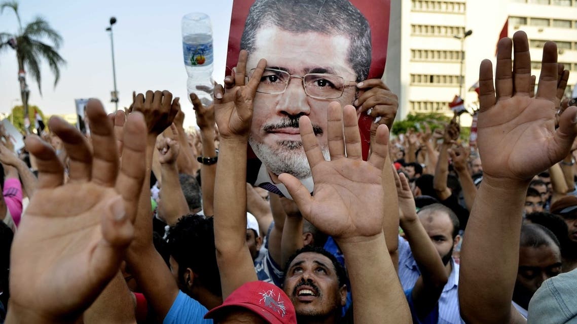 Egyptian supporters of the Muslim Brotherhood hold pictures of deposed president Mohamed Mursi as they shout slogans during a demonstration outside the Republican Guards headquarters in Cairo on July 5, 2013. (AFP)