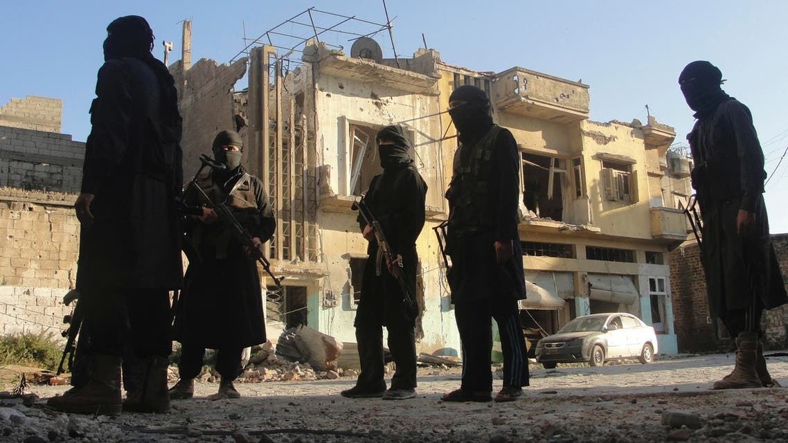 Free Syrian Army members accompanied by fighters from the Islamist Syrian rebel group Jabhat al-Nusra carry their weapons as they stand in front of a damaged building in the old city of Homs July 2, 2013.