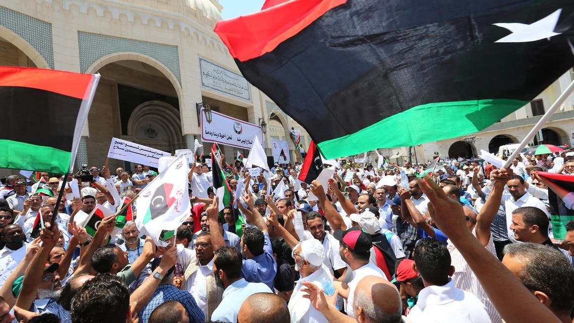 Libyan protesters shout slogans waving national flags during a demonstration on the Algeria Square to demand the removal of arms and the evacuation of unofficial armed groups and the implementation of the General National Congress (GNC)'s decision on July 7, 2013 in the Libyan capital Tripoli. (AFP)