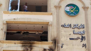 A looter stands near a broken window at the Muslim Brotherhood's headquarters after it was burned down by protesters opposing Egyptian President Mohamed Mursi in Cairo's Moqattam district in this July 1, 2013 file picture.