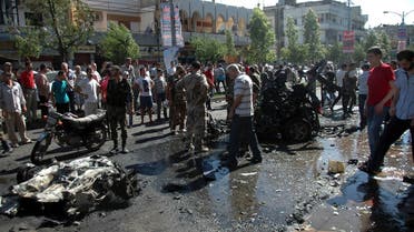 People stand at the site of an explosion in Ekrema neighbourhood in Homs city July 8, 2013, in this handout photograph released by Syria's national news agency SANA. Reuters