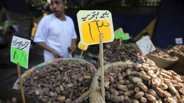 A shopkeeper checks his supplies of dates near a sign reading, Tahrir Square Dates at a market a day ahead of the Muslim fasting month of Ramadan in Cairo July 9, 2013. (Reuters)
