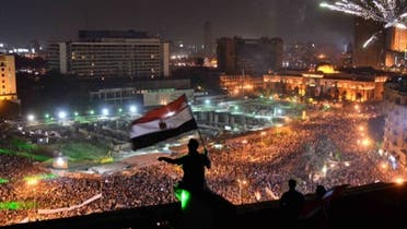Egyptians wave the national flag on a building rooftop on July 7, 2013 as hundreds of thousands flood Egypt's landmark Tahrir square to demonstrate against ousted President Mohammad Mursi. (AFP)