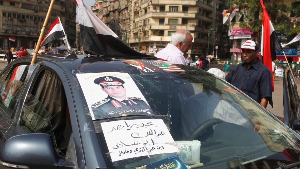 A man with a poster of the chief of Egypt’s armed forces General Abdel Fattah al-Sisi on his car, talks to a protester in Tahrir square, in Cairo, July 9, 2013. Sign reads, “I love Egypt.” (Reuters)
