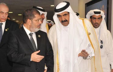 Ousted Egyptian President Mohammad Mursi (L) speaks with former Qatari leader Emir Sheikh Hamad bin Khalifa al-Thani during the 16th summit of the Non-Aligned Movement in Tehran, 30 August 2012. (File Photo: Reuters)