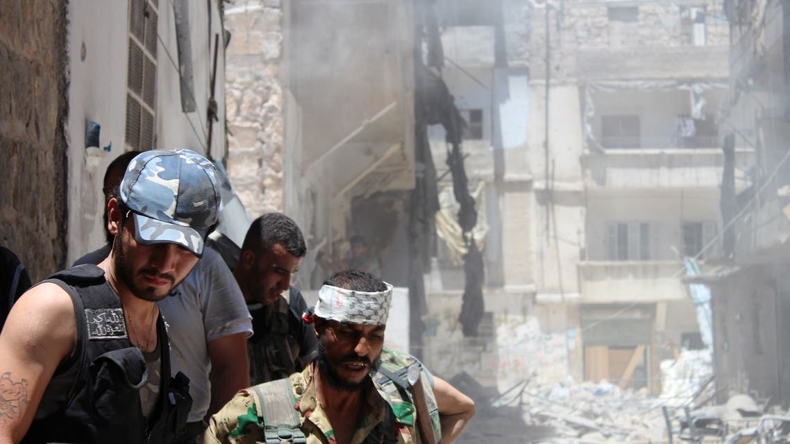 Syrian rebels gather outside a building which they blew up to target a regime sniper taking shelter inside but who managed to escape in the Salaheddine district of the northern city of Aleppo on July 10, 2013. (File photo: AFP)