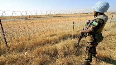A Rwandan peacekeeper serving with the joint United Nations-African Mission in Darfur (UNAMID) stands guard in a field in Zalingei in western Darfur. (File Photo: AFP)