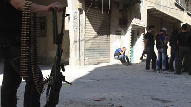 Free Syrian Army fighters hold their weapons as they gather along a street near the frontline where clashes with forces loyal to Syria's President Bashar al-Assad are taking place in Beit Hajira near Damascus, July 7, 2013.