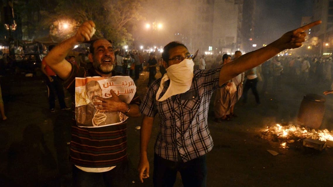 Supporters of deposed president Mohammed Morsi hold a picture of him during a rally in Cairo's Ramsis square under the Six of October bridge on July 15, 2013. AFP