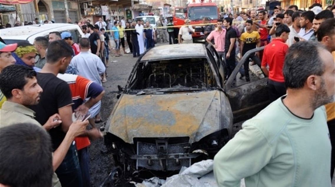 People gather at the site of a car bomb attack in Kut city, southeast of Baghdad. (Reuters)