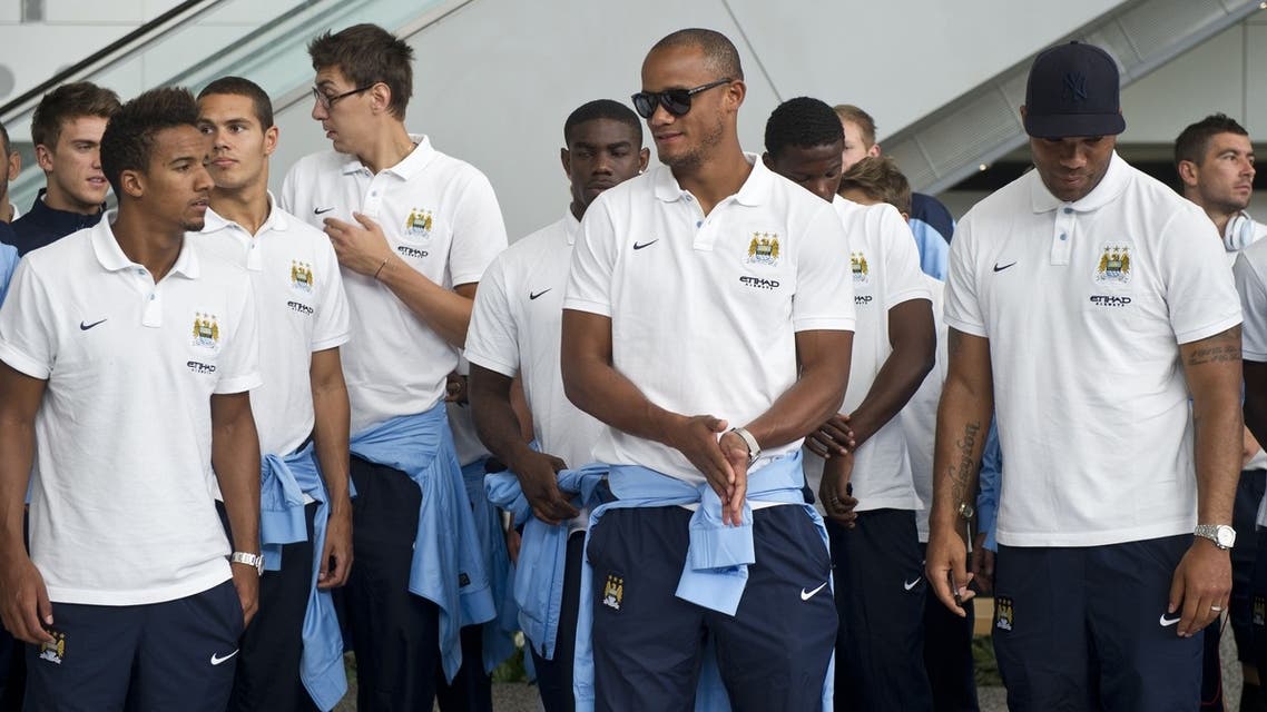 English Premier League football team Manchester City players Scott Sinclair (front L), captain Vincent Kompany (front C) and Joleon Lessott (front R) arrive in Hong Kong on July 22, 2013. (AFP)