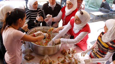 Syrian volunteers pack food for distribution to the poor and displaced during the Go Away Hunger charity campaign in the fasting month of Ramadan in old Damascus. (File Photo: Reuters)