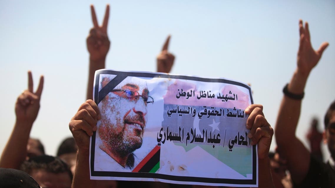 Men hold up a picture of slain prominent Libyan political activist Abdelsalam al-Mosmary, during his funeral in Benghazi July 27, 2013. (Reuters)