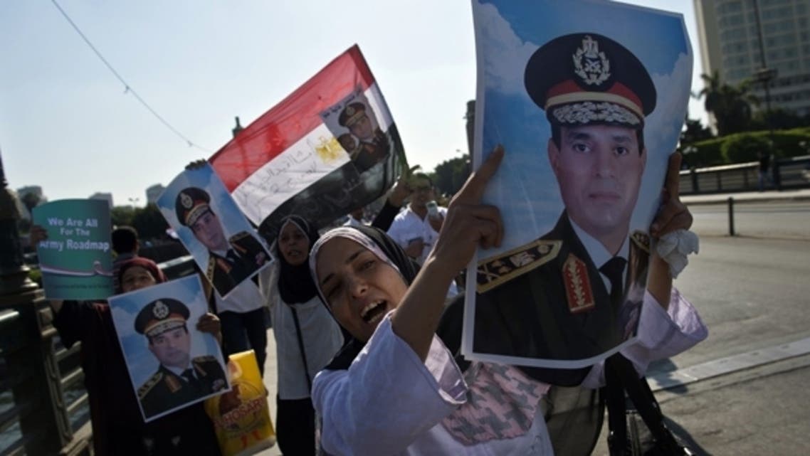 Supporters of army chief General Abdel Fattah al-Sisi carry his portrait and wave the Egyptian flag in Cairo's Tahrir square on July 16, 2013. (AFP)