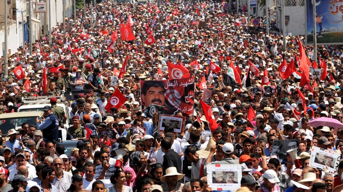 Tunisians join the funeral procession of opposition leader Mohammad al-Brahimi after it left his home in the Tunis suburb of Ariana on July 27, 2013. (AFP)