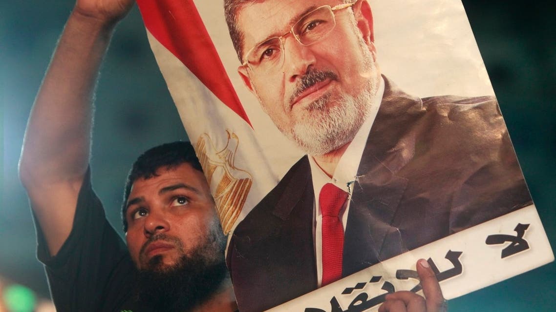 A supporter of deposed Egyptian President Mohamed Mursi carries a Mursi poster during a protest at the Rabaa Adawiya square, where Mursi supporters are camping, in Cairo July 27, 2013.